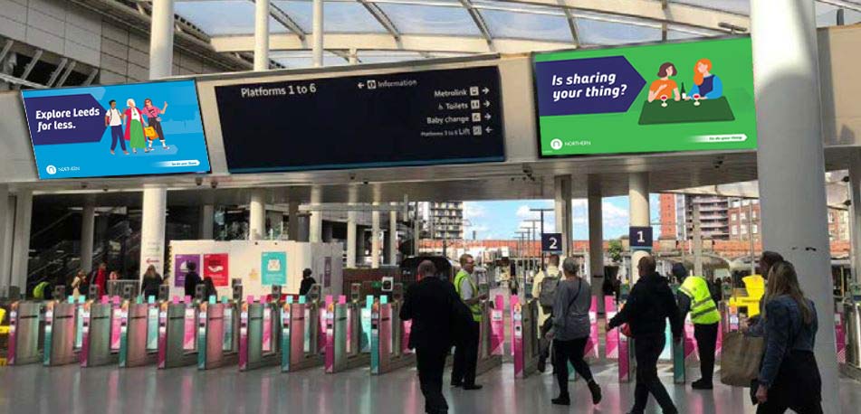 Commuters on a London Underground station platform with advertising space